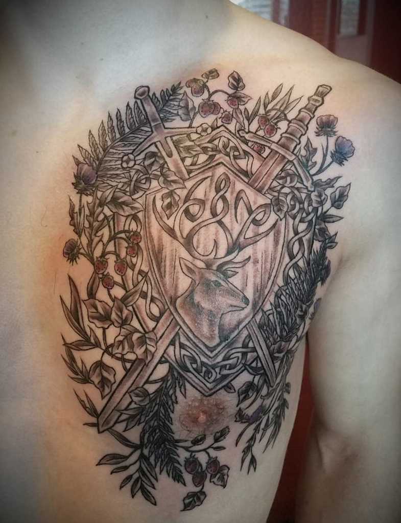 A tatuagem do escudo com um cervo na cara no peito