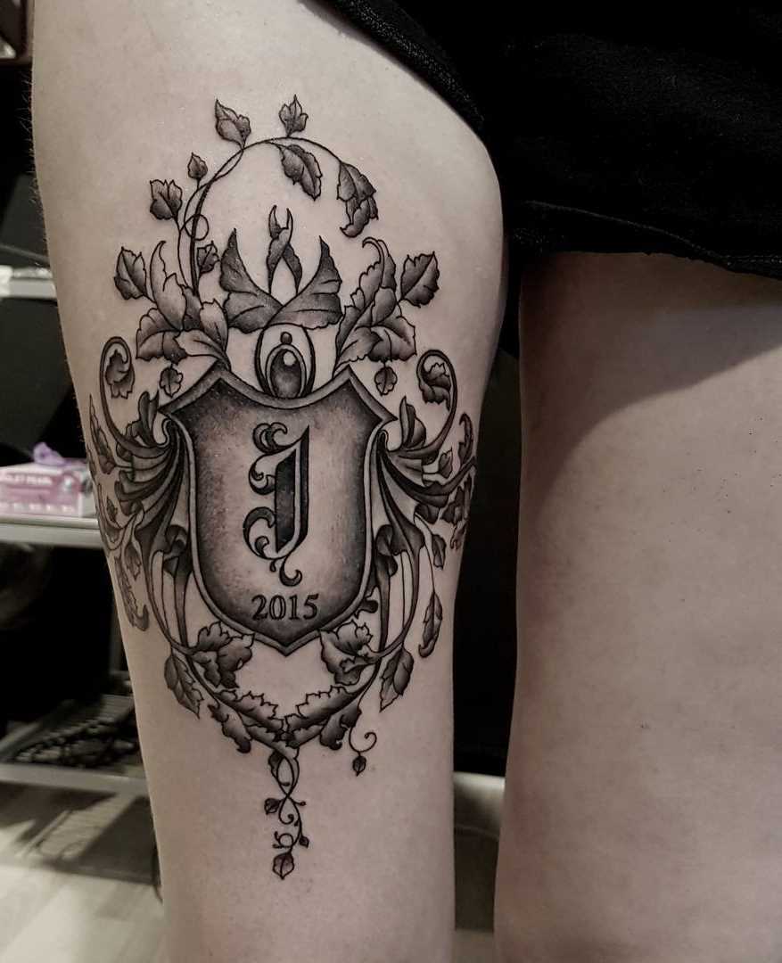 A tatuagem do escudo na altura do quadril de uma mulher