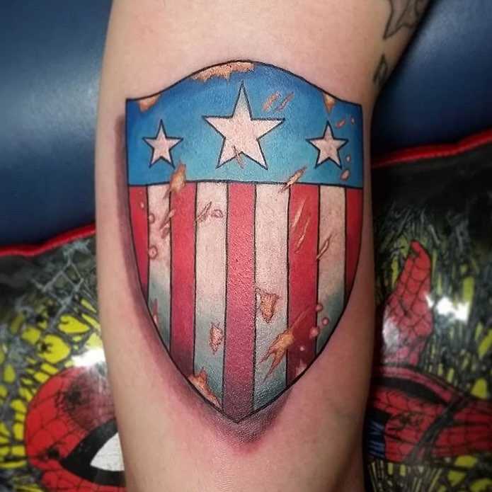 A tatuagem do escudo na mão de um cara