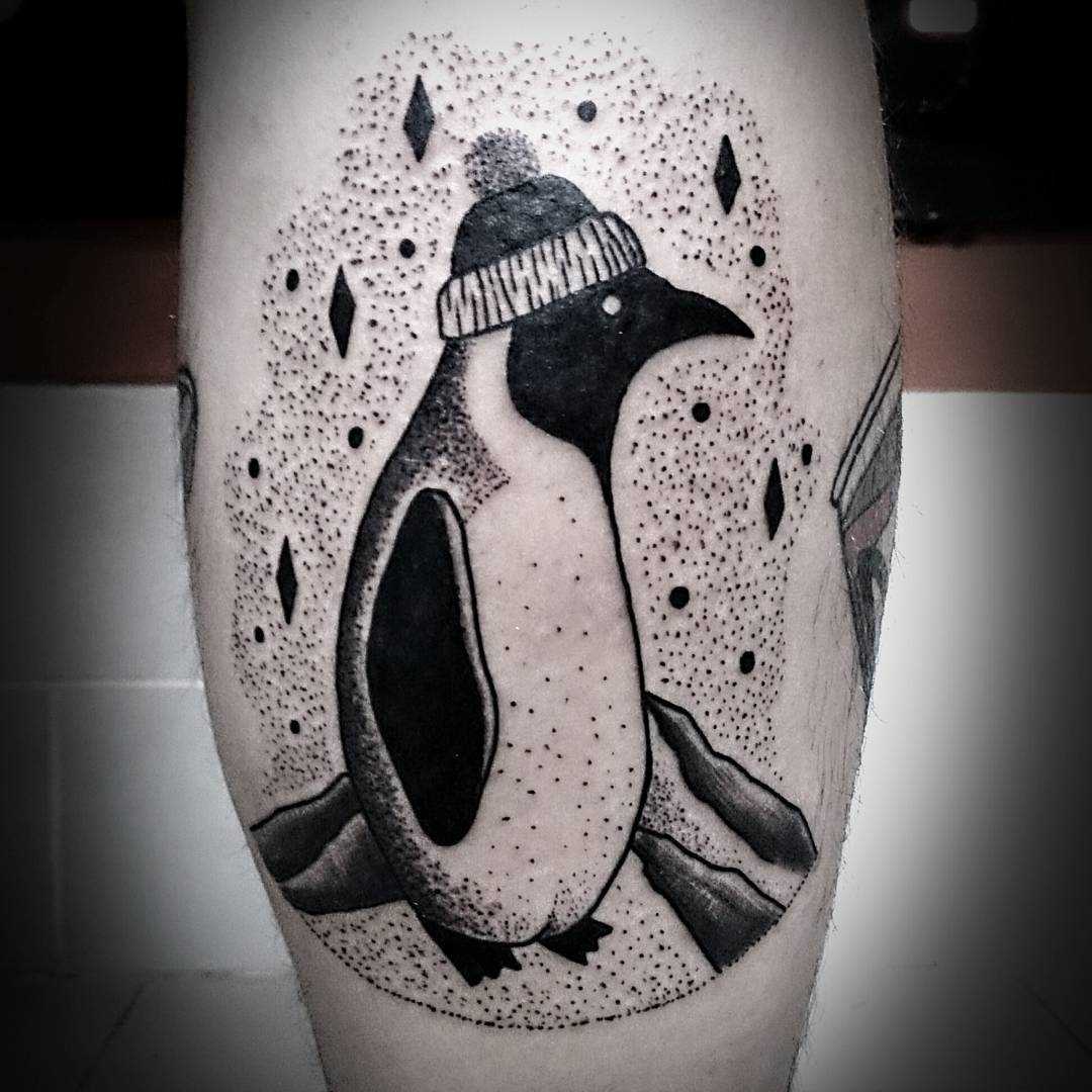 A tatuagem do pinguim sobre a perna de um cara