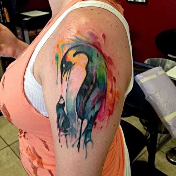 A tatuagem do pinguim sobre o ombro de uma mulher