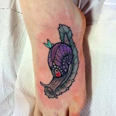 A tatuagem é um caracol na planta do pé da menina