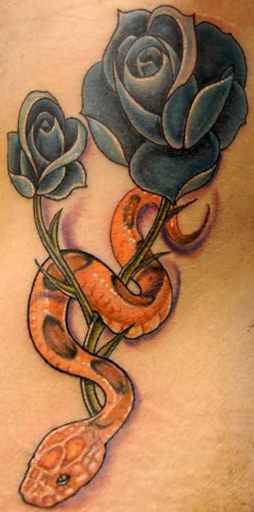 A tatuagem em forma de cobra e de rosas sobre a barriga da menina