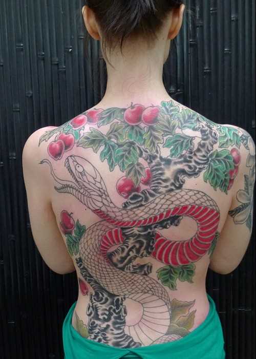 A tatuagem em forma de serpente e a maçã na parte de trás da menina