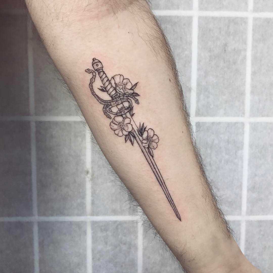 A tatuagem espada com flores no antebraço cara