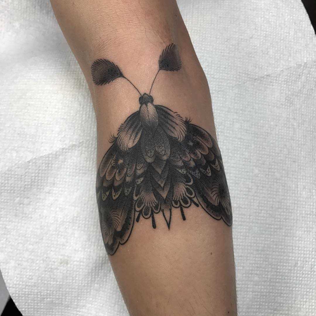 A tatuagem inseto sobre a perna de um cara