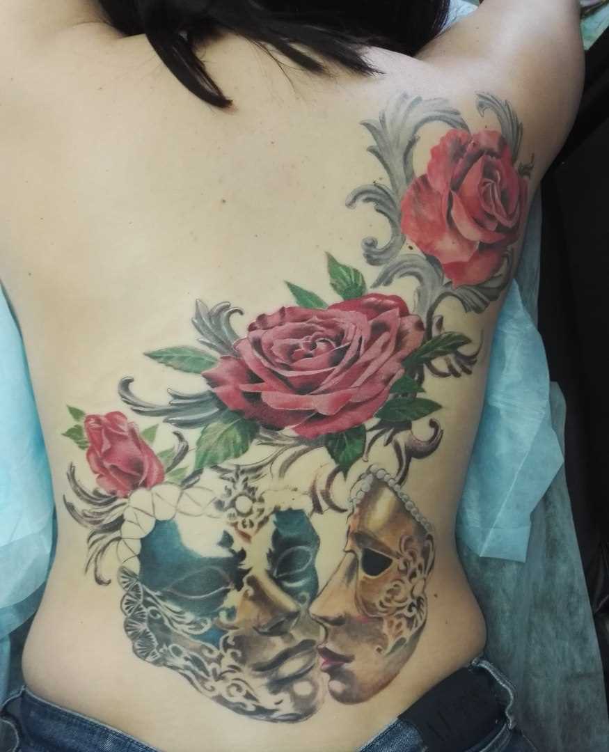 A tatuagem nas costas de uma menina - a máscara e a rosa