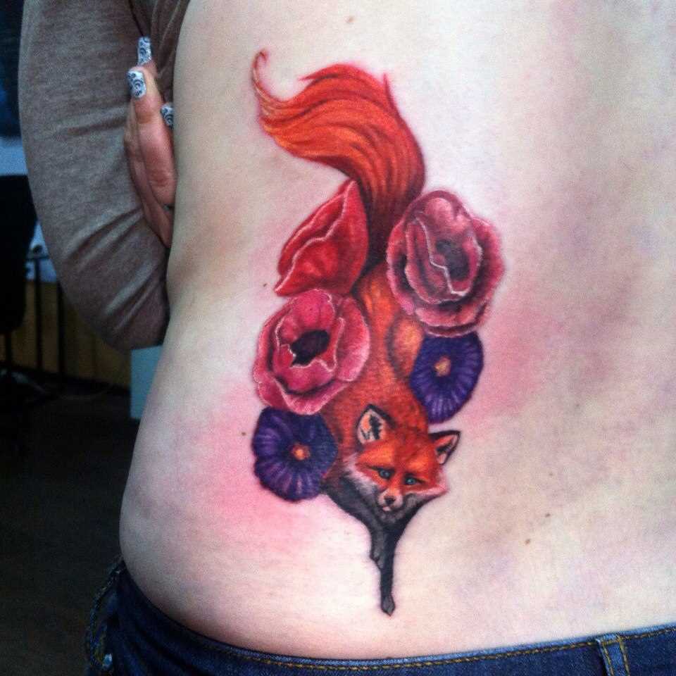 A tatuagem nas costas de uma menina - a raposa e as cores