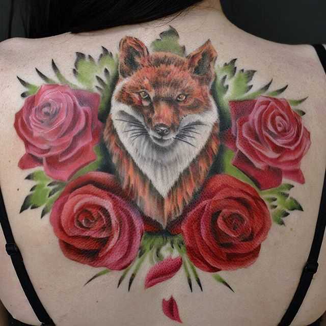 A tatuagem nas costas de uma menina - a raposa e as rosas
