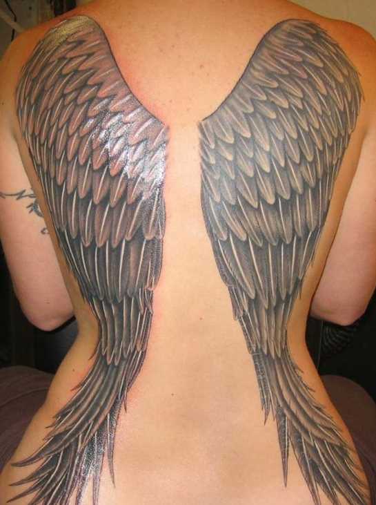 A tatuagem nas costas de uma menina com a imagem de asas