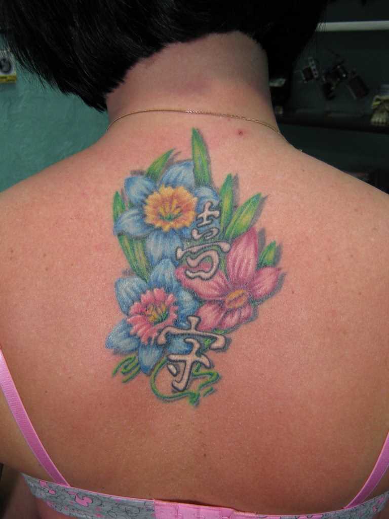 A tatuagem nas costas de uma menina - cores e personagens