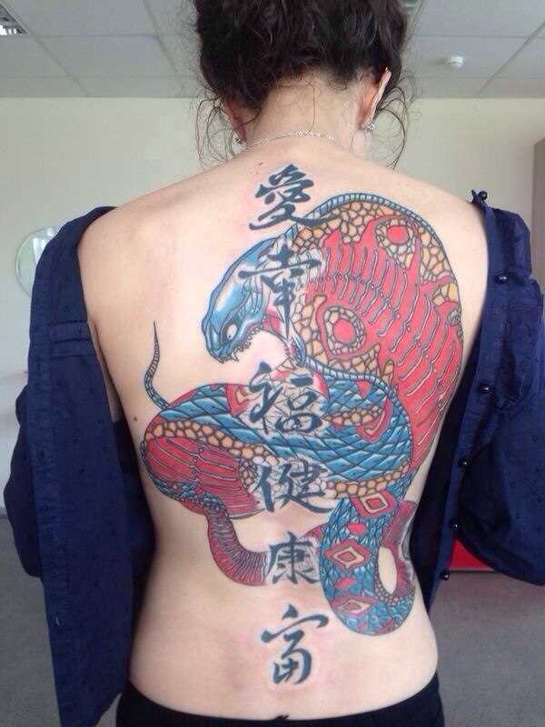 A tatuagem nas costas de uma menina de cobra e personagens