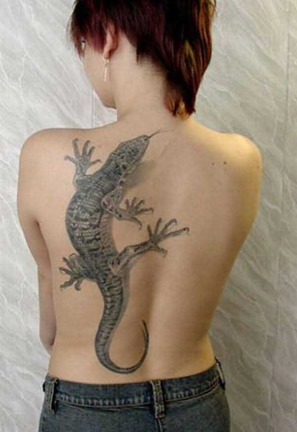 A tatuagem nas costas de uma menina em forma de um grande lagarto