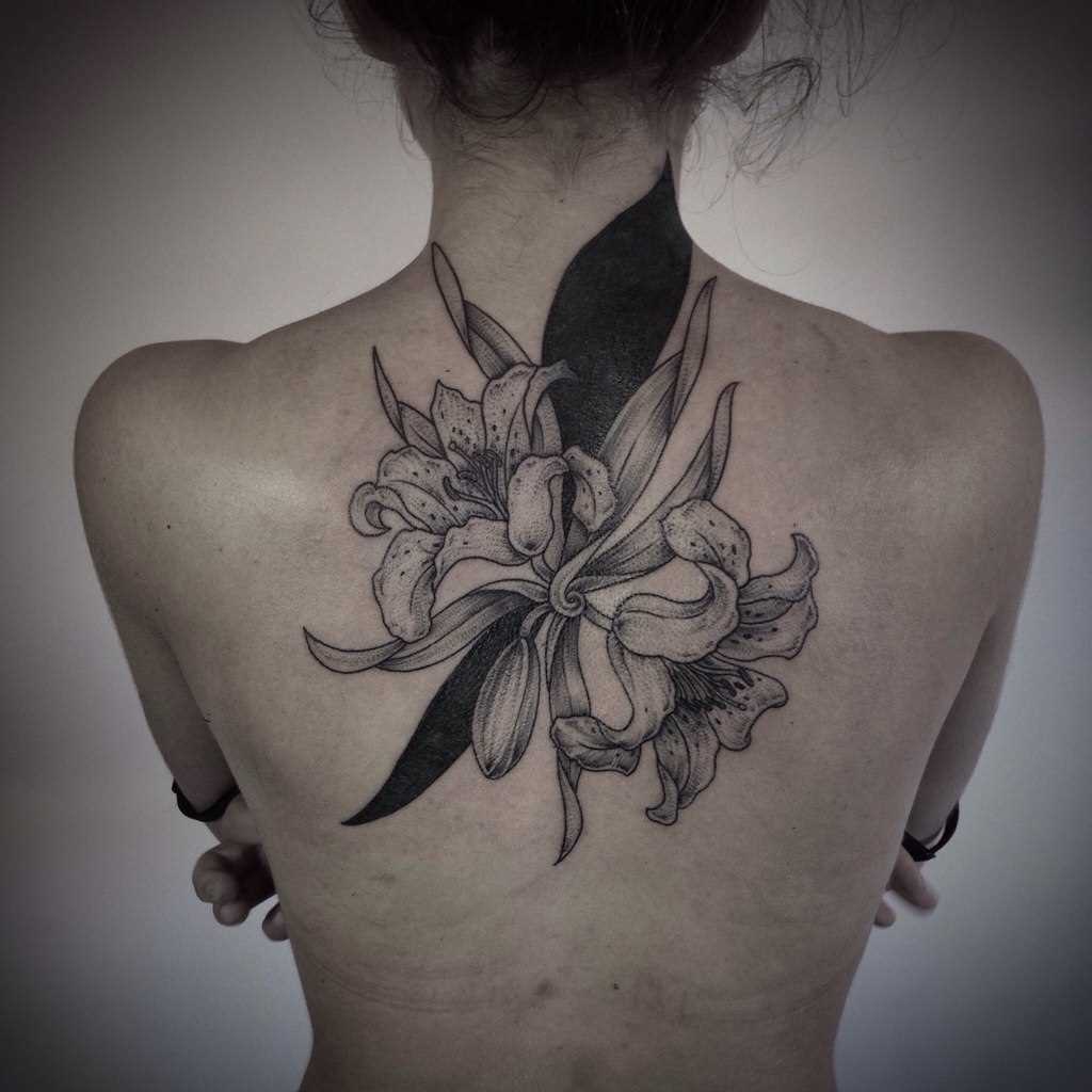 A tatuagem nas costas de uma menina - lírio