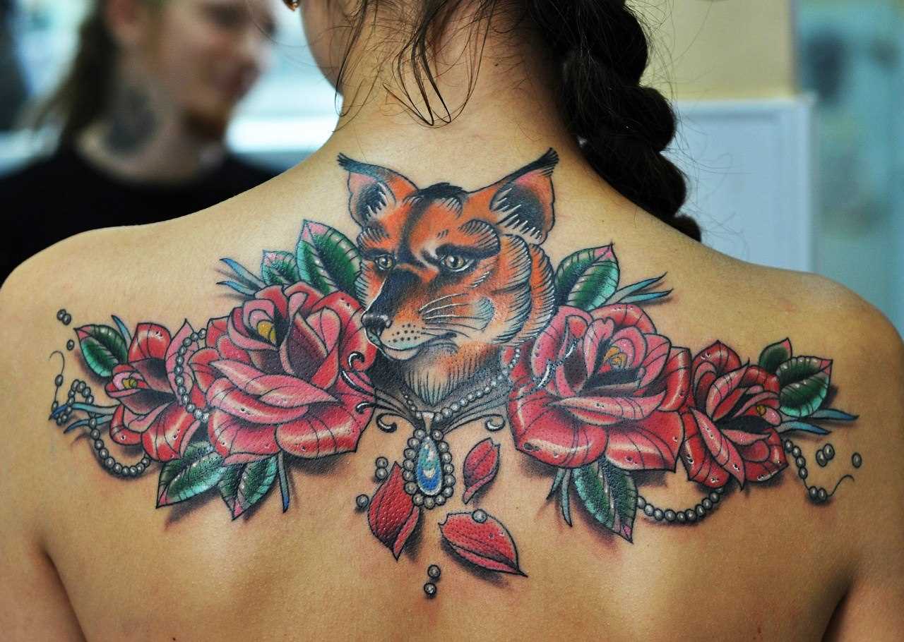 A tatuagem nas costas de uma menina - lis e rosas