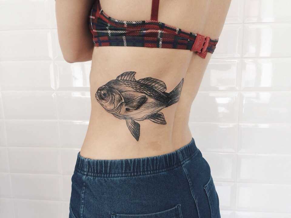 A tatuagem nas costas de uma menina - peixe