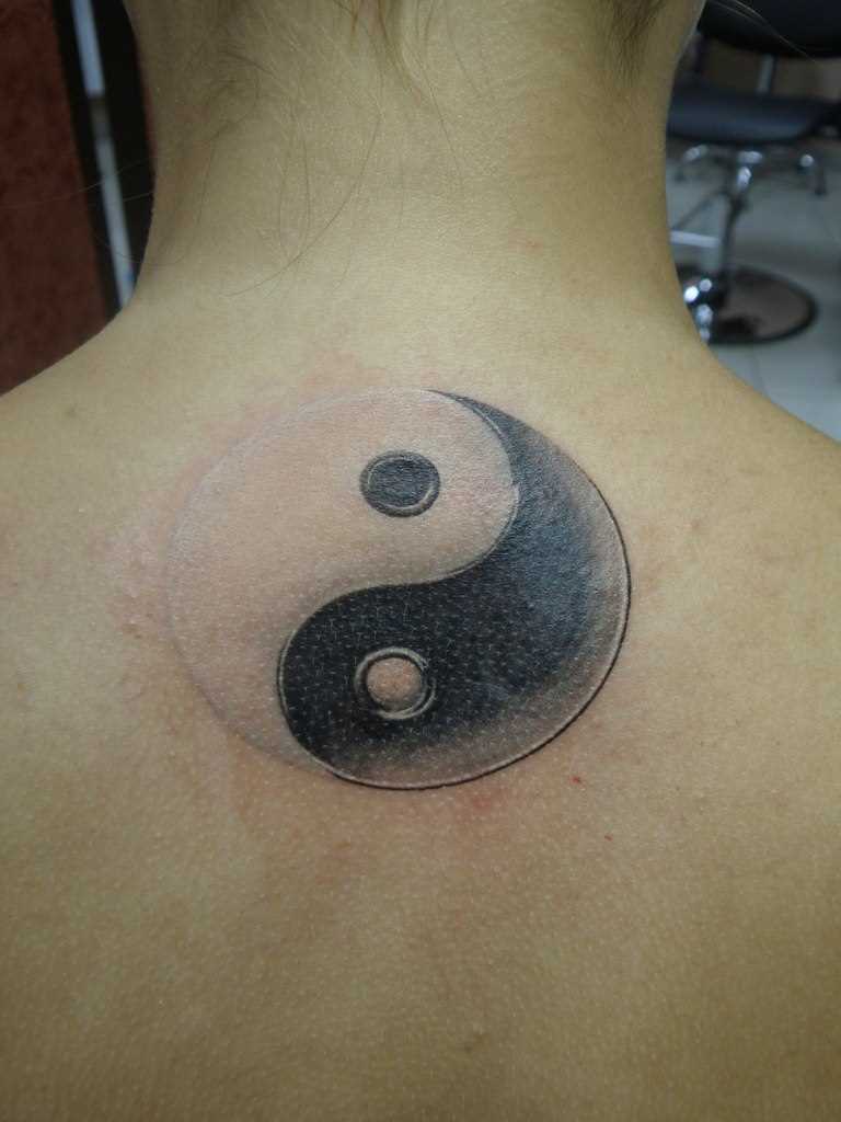 A tatuagem nas costas de uma menina - Yin-Yang