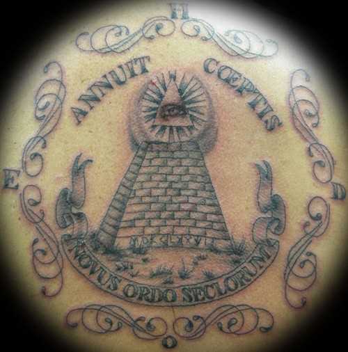 A tatuagem nas costas do cara - a pirâmide com o olho e inscrição