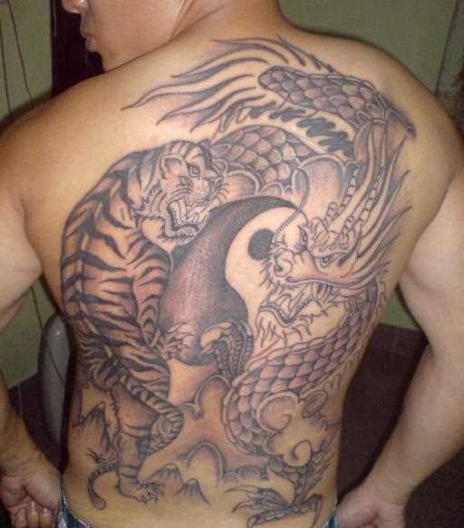A tatuagem nas costas do cara com a imagem de um dragão e do tigre e do símbolo do Yin-Yang