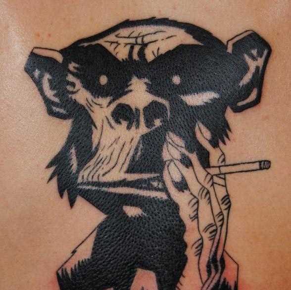 A tatuagem nas costas do cara - de- macaco com um cigarro