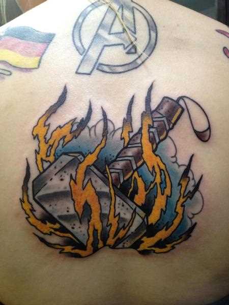 A tatuagem nas costas do cara - de-martelo e o fogo