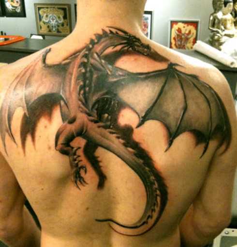 A tatuagem nas costas do cara em forma de um dragão voando