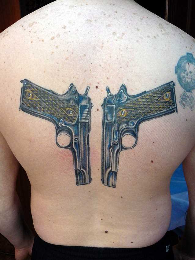 A tatuagem nas costas do cara - pistolas
