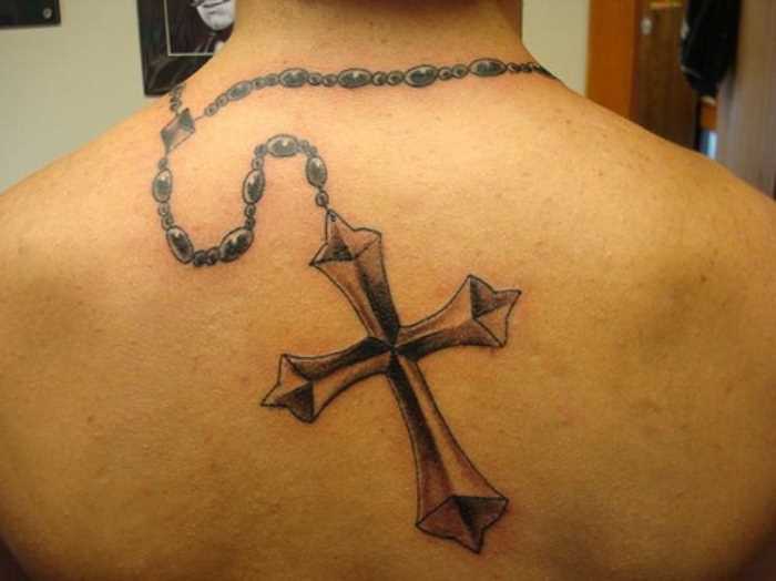 A tatuagem nas costas do cara - um colar com uma cruz