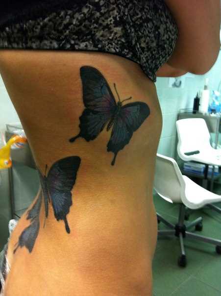 A tatuagem nas costas e costelas menina - borboleta