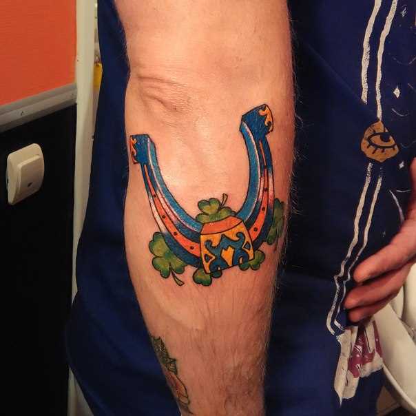 A tatuagem no braço de um cara - de- ferradura e trevo