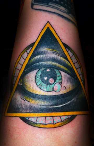 A tatuagem no braço de uma menina - a pirâmide com o olho