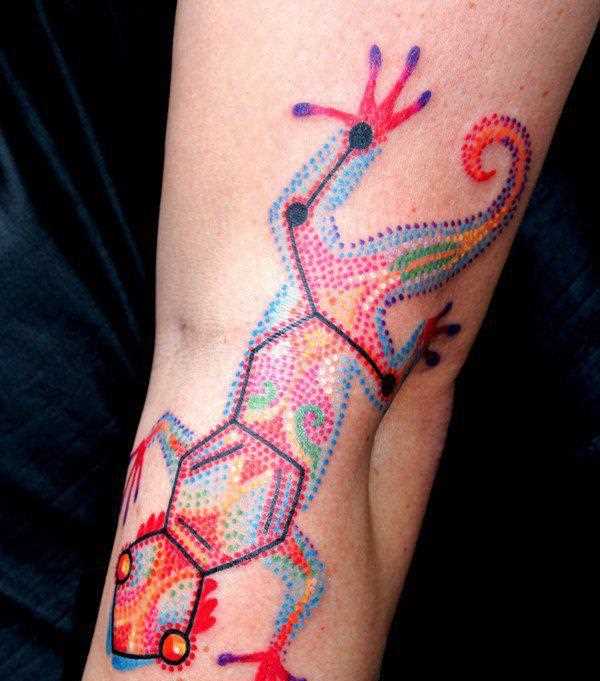 A tatuagem no braço de uma menina em forma de lagarto
