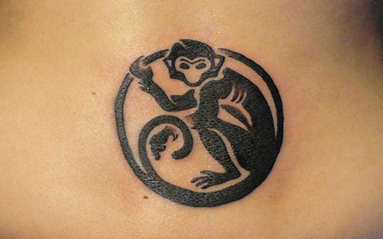 A tatuagem no cóccix menina - macaco