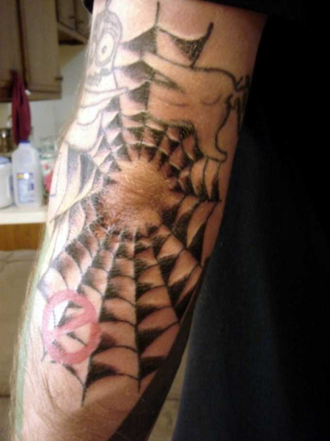 A tatuagem no cotovelo do cara com a imagem da web