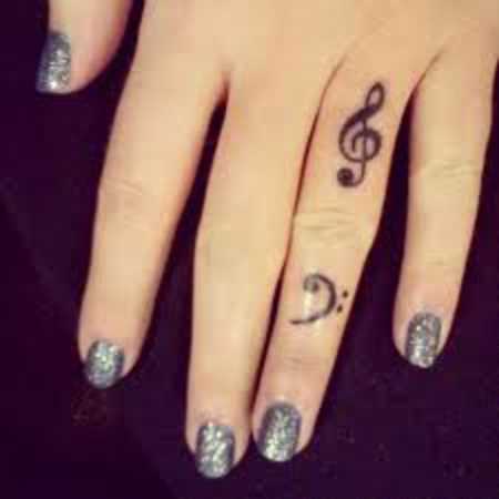 A tatuagem no dedo de uma menina - clave de sol