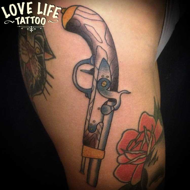 A tatuagem no estilo oldschool no quadril da menina - arma