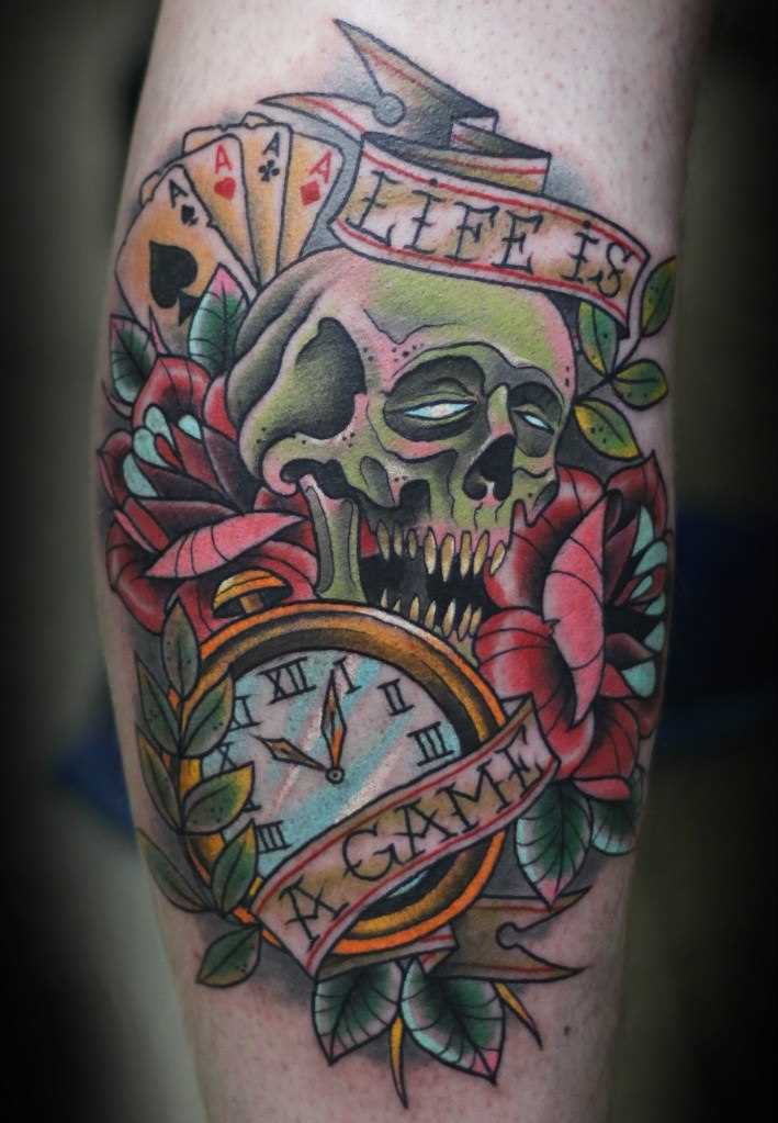 A tatuagem no estilo oldschool sobre a perna de um cara de crânio e relógios