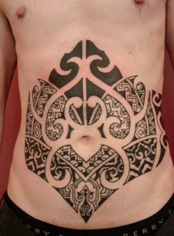 A tatuagem no estilo tribal na barriga do cara
