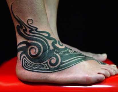 A tatuagem no estilo tribal na planta do pé de um cara - padrões