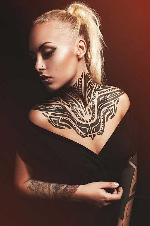 A tatuagem no estilo tribal no peito e pescoço da menina