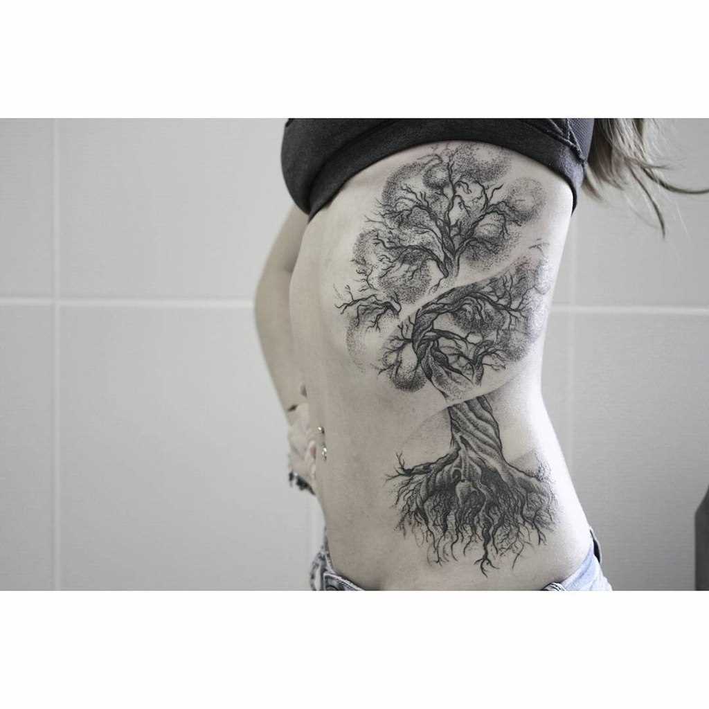 A tatuagem no lado da menina - árvore