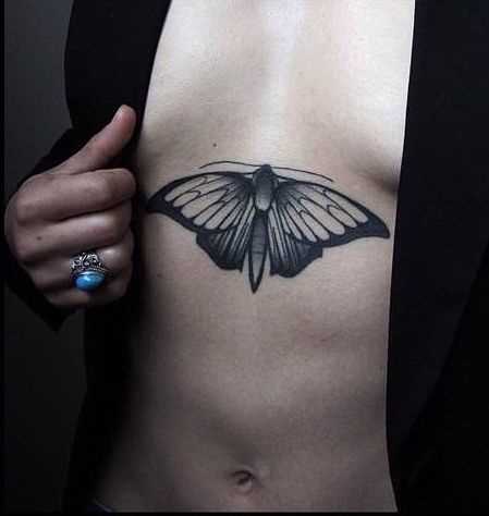 A tatuagem no lado da menina - borboleta