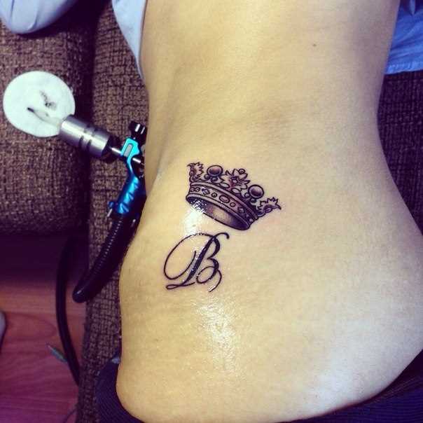 A tatuagem no lado da menina - coroa letra A