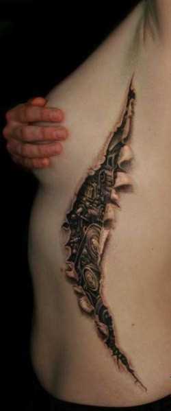 A tatuagem no lado da menina no estilo de biomecânica