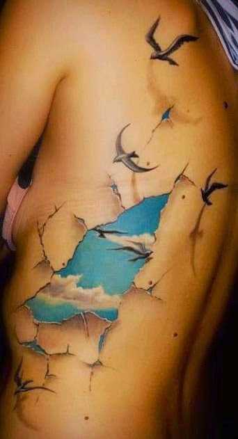 A tatuagem no lado da menina - o céu e a gaivota