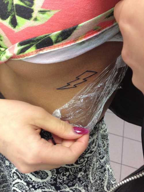 A tatuagem no lado da menina - relâmpago
