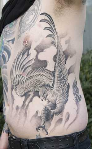 A tatuagem no lado de um cara - de- falcão