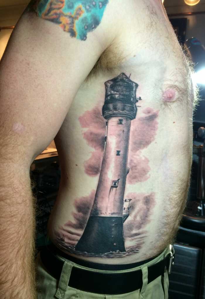 A tatuagem no lado de um cara - farol