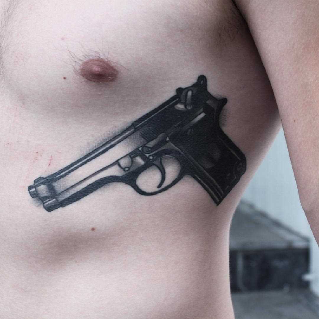 A tatuagem no lado do cara - a arma