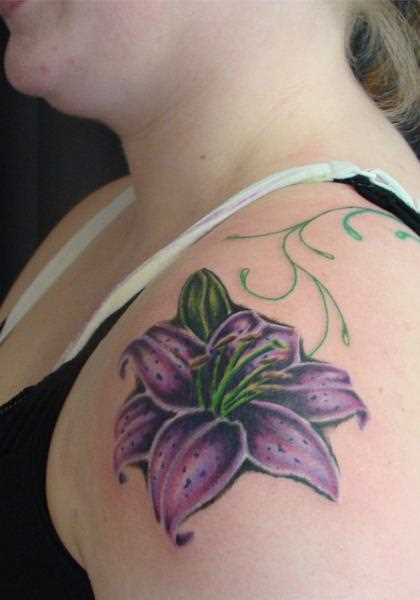 A tatuagem no ombro da menina como uma flor de lírio